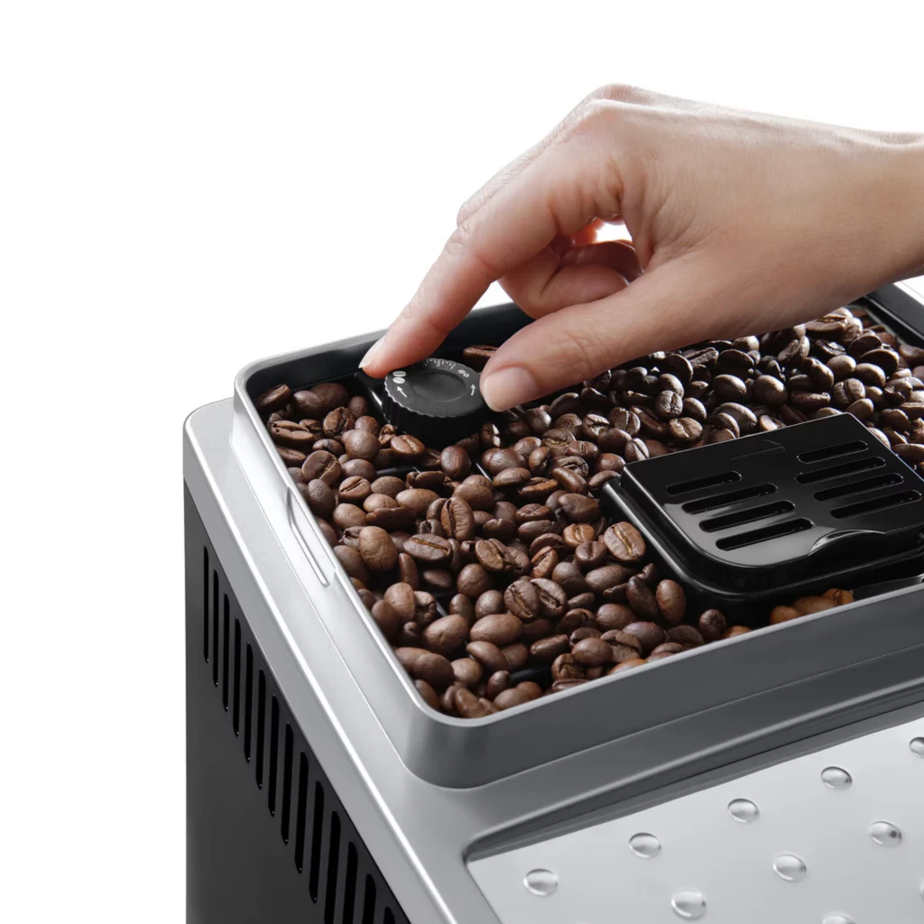 Tolva de granos con ajuste de molienda mediante perilla, acabados en acero y tapa negra; detalle de la DeLonghi Magnifica S ECAM250.23.SB 1.8L 15 bares