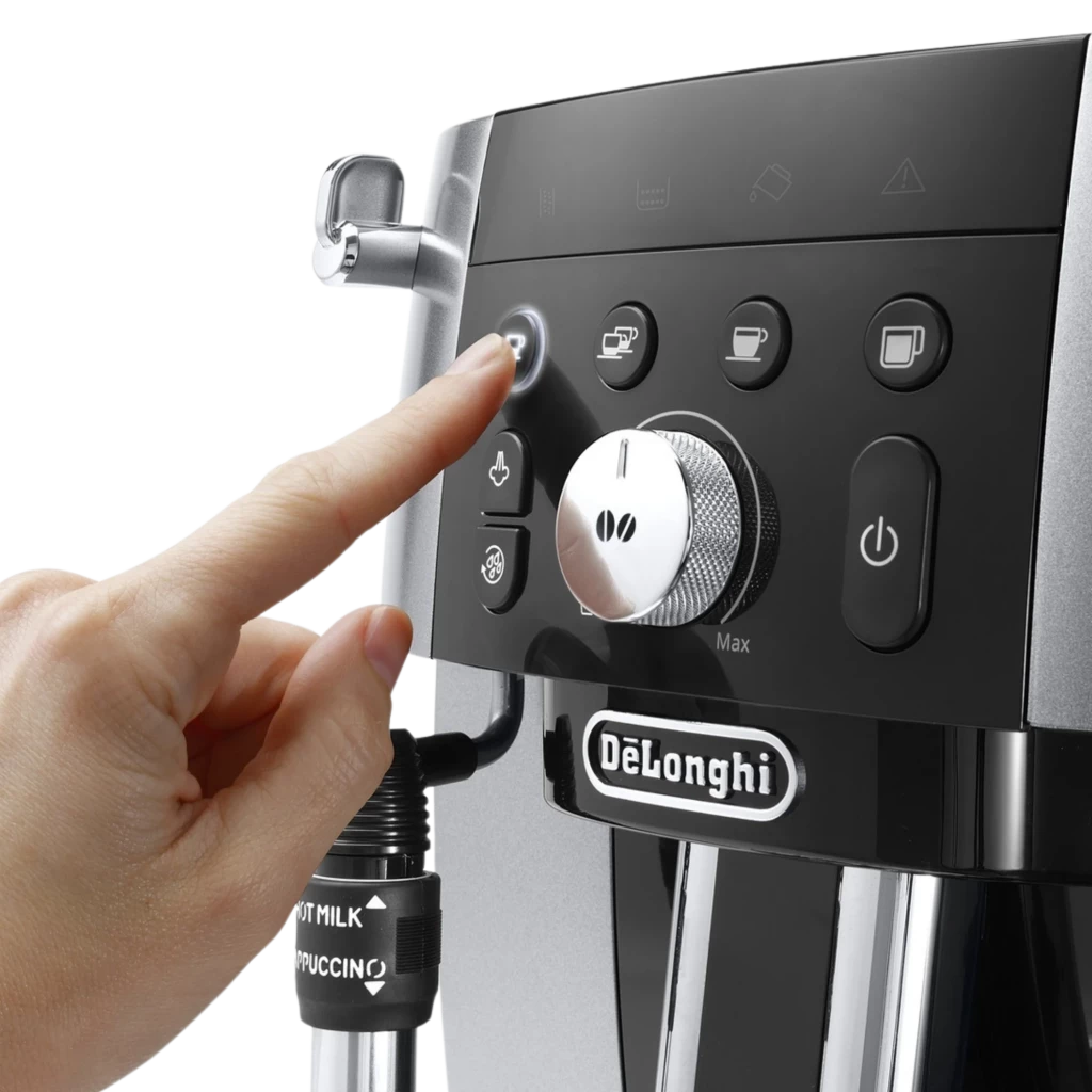 Panel frontal de la DeLonghi Magnifica S con botón iluminado, dial central de molienda, iconos de bebidas y vaporizador de leche HOT MILK/CAPPUCCINO