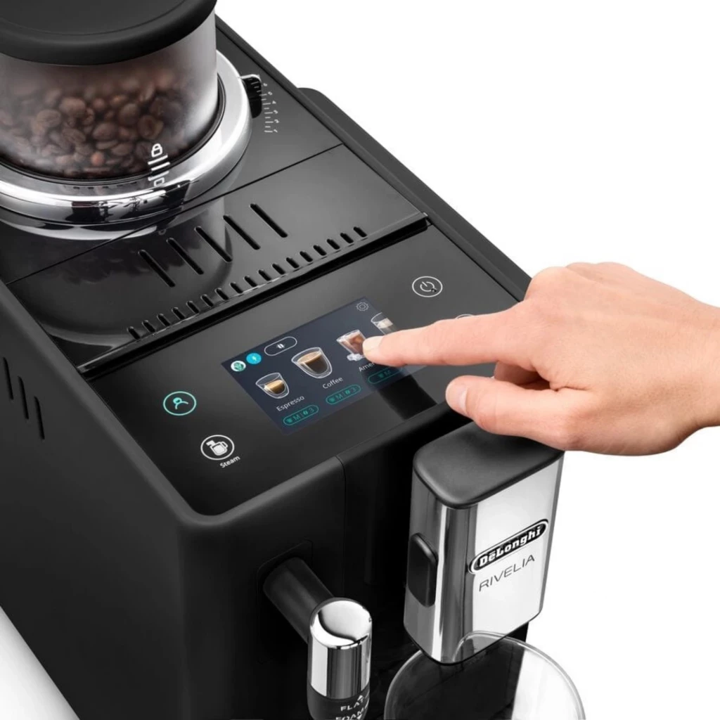 Painel tátil 3,5 pol com ícones de bebidas, bico de café inox, reservatório frontal e moedor com grãos visíveis na DeLonghi Rivelia EXAM440.35.B