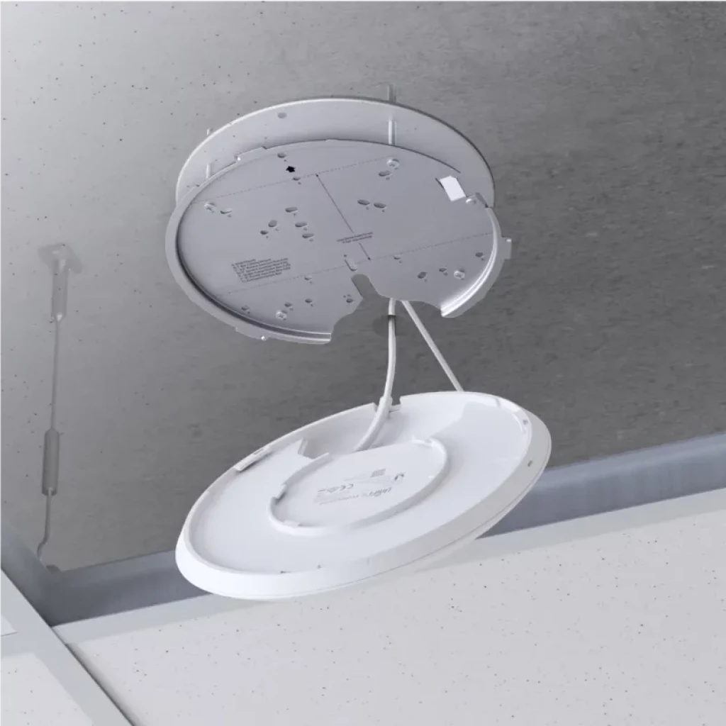 Punto de acceso Ubiquiti U6 Enterprise blanco, montaje en techo con placa y cables visibles, diseño circular minimalista, compatible PoE y WiFi 6E 4800 Mbit/s