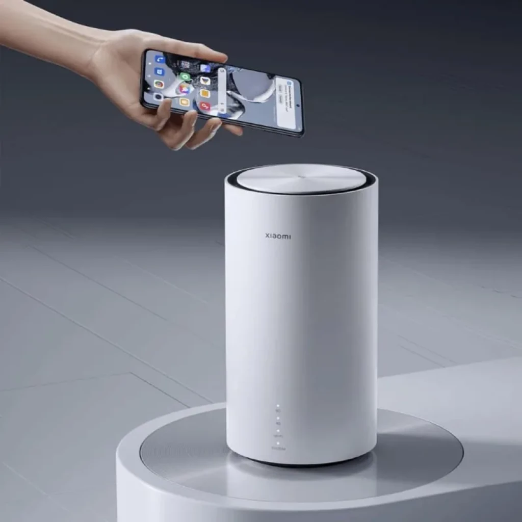 Xiaomi 5G CPE Pro en color blanco, diseño cilíndrico minimalista con tapa metálica, logo Xiaomi y LEDs frontales de estado; base circular gris elegante