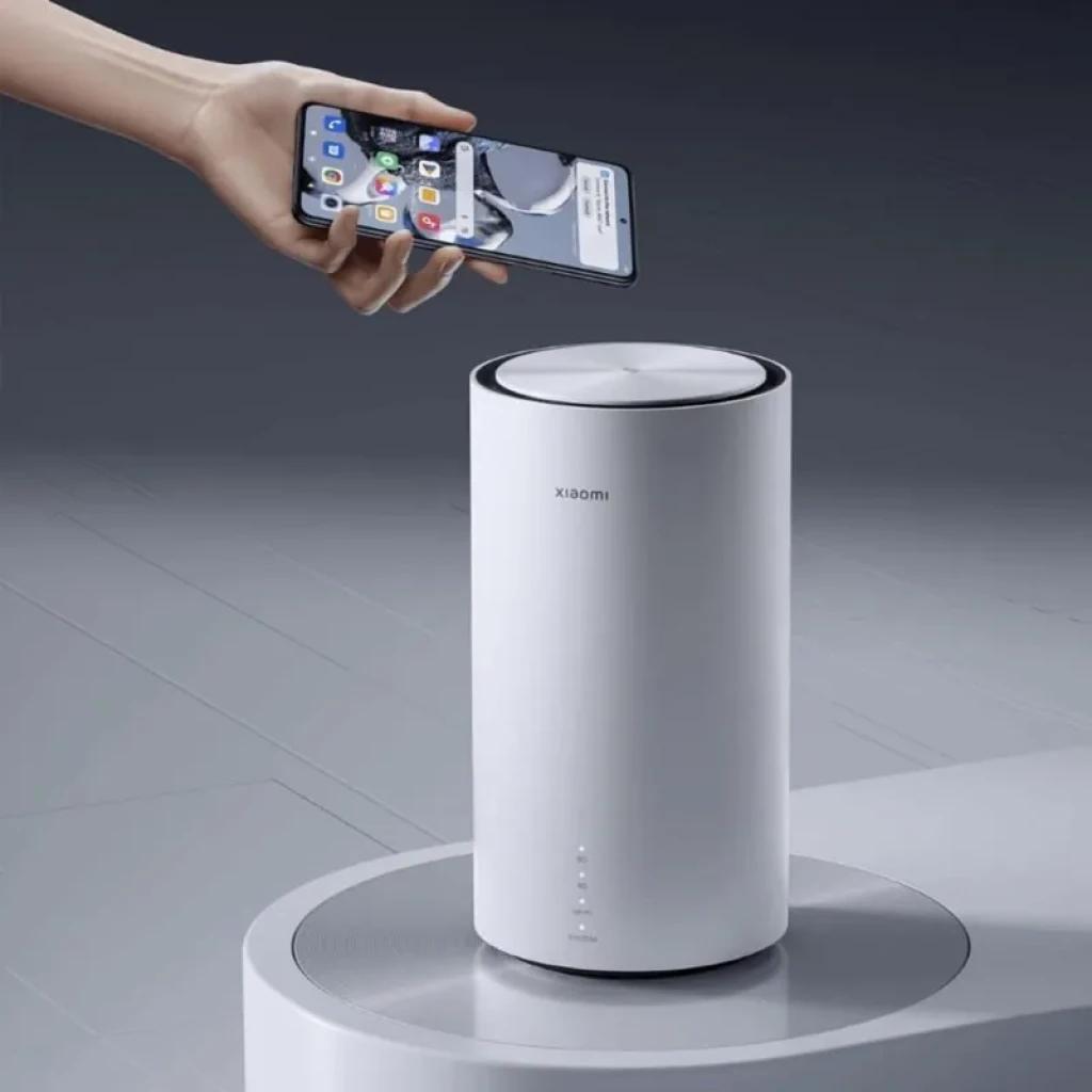 Xiaomi 5G CPE Pro en color blanco, diseño cilíndrico minimalista con tapa metálica, logo Xiaomi y LEDs frontales de estado; base circular gris elegante