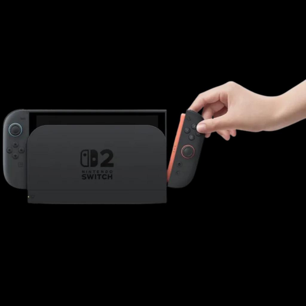 Nintendo Switch 2 em dock preto com logo, tela à esquerda e Joy-Con vermelho sendo encaixado por uma mão; design compacto e moderno