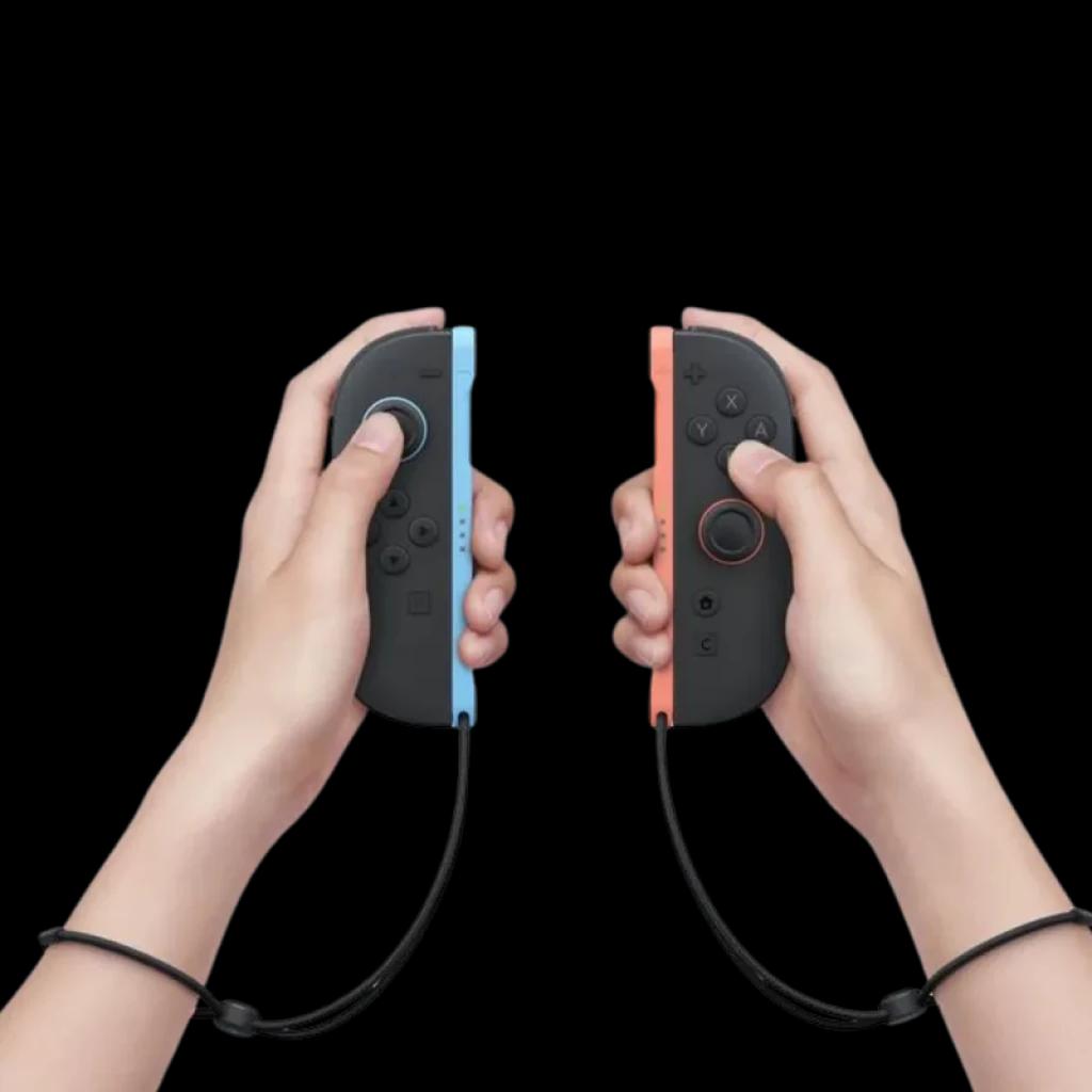 Controles Joy-Con do Nintendo Switch 2 em preto com laterais azul e vermelho, presos por alças, mostrados nas mãos para jogo portátil e multijogador.