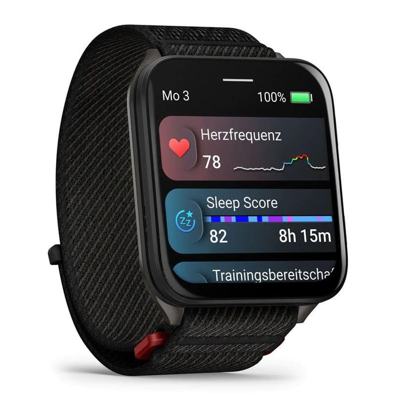 Garmin Venu X1 con caja de titanio gris y correa de nailon negro; pantalla cuadrada con métricas de salud, bordes redondeados y hebilla resistente