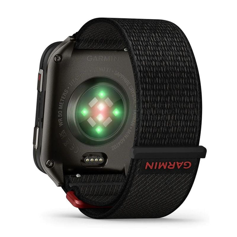 Garmin Venu X1 con caja de titanio gris, sensor óptico trasero iluminado, correa de nailon ComfortFit negra con cierre ajustable y detalle rojo