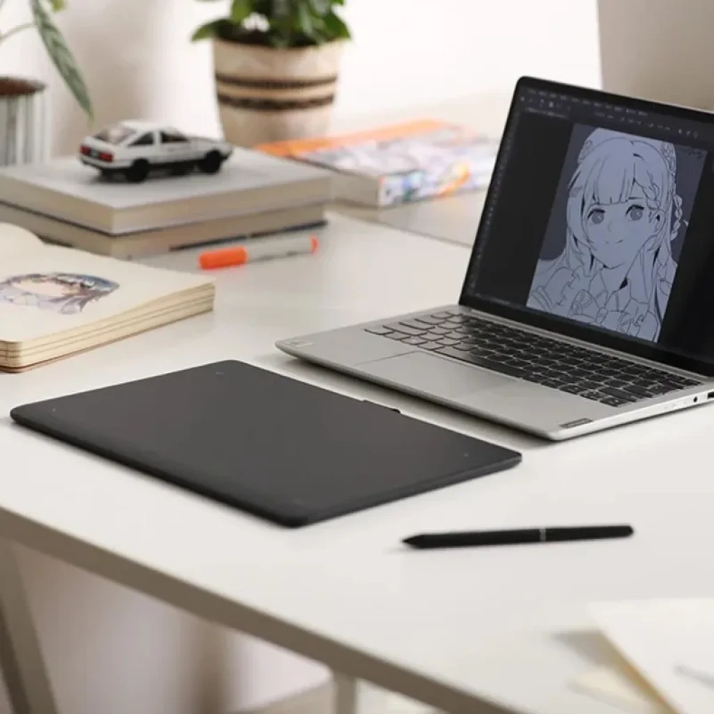 Tableta gráfica Huion Inspiroy Frego M L610 con lápiz PW550S en escritorio; superficie negra amplia, botones sutiles y conectividad Bluetooth 5.0