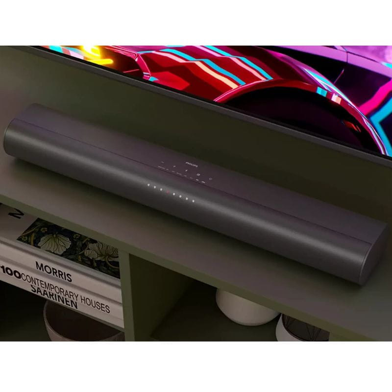 Barre de son grise compacte avec LED d’état sur le dessus, design épuré sous TV, finitions mates, compatible avec subwoofer pour setup 2.1 80 W