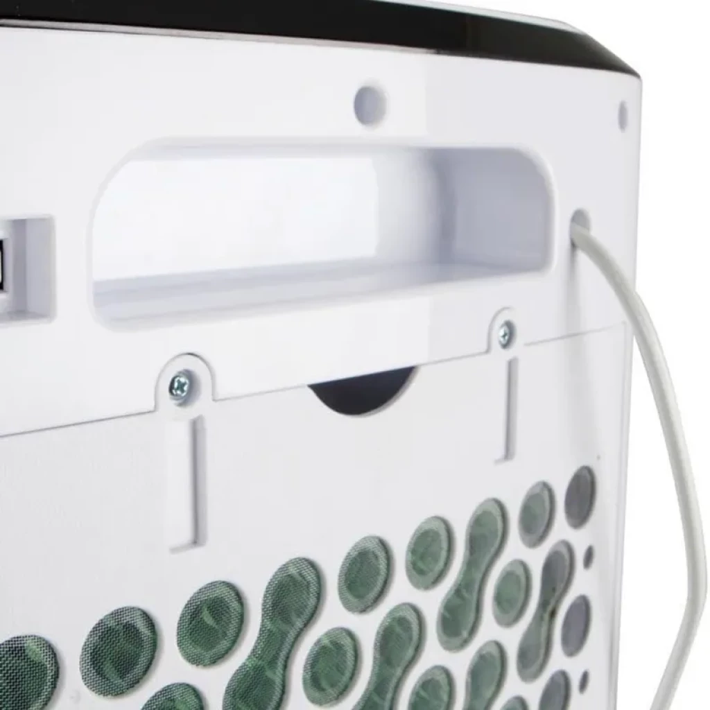 Panneau arrière blanc avec poignée intégrée, vis apparentes et câble latéral; grille à motifs ronds protégeant le filtre vert du climatiseur portable