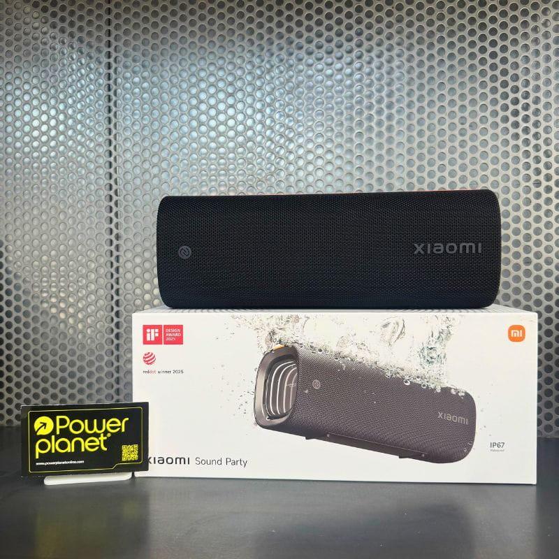 Xiaomi Sound Party altavoz portátil negro con rejilla frontal, diseño rectangular, botones superiores y resistencia IP67; caja con imagen salpicaduras de agua