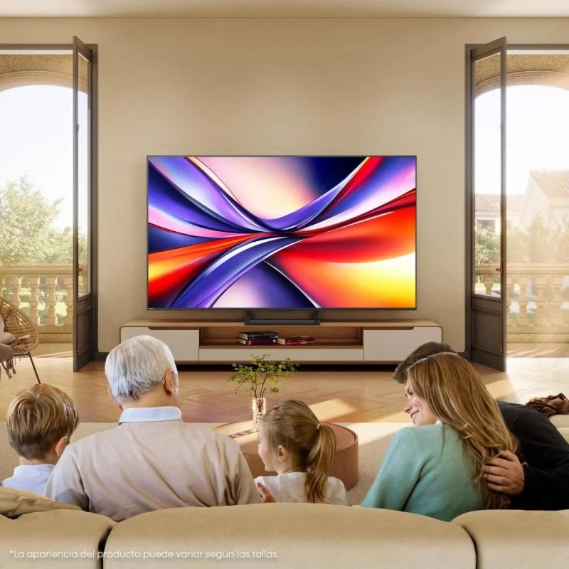 TV Hisense 55A7Q 55" 4K UHD preta em sala iluminada; tela grande com cores vibrantes e bordas finas, apoiada em rack baixo com portas de varanda ao fundo.