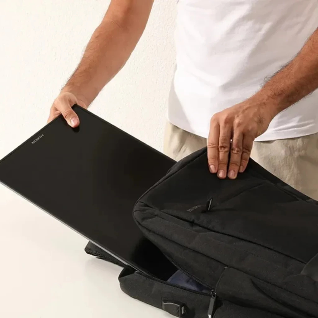 Huion Kamvas Pro 16 GT1602 com tela 15,8 pol 2,5K 186 ppi sendo guardada em mochila; corpo fino e preto, bordas estreitas, design portátil