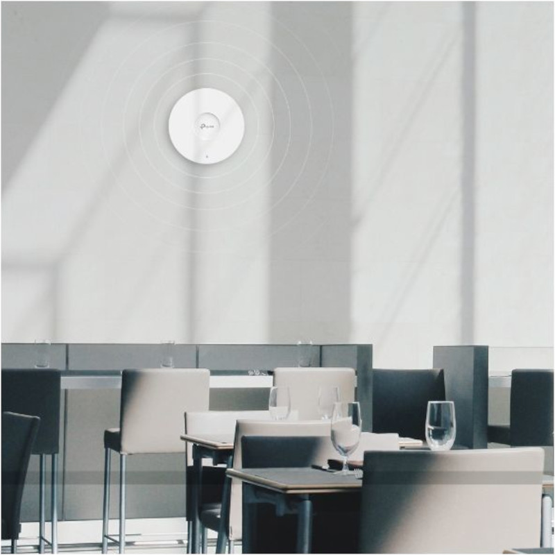 TP-Link Omada EAP653 Techo montado en pared, diseño circular blanco, indicador LED central, ondas Wi-Fi visibles, ambiente moderno de oficina o cafetería