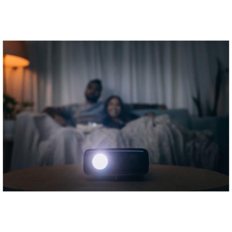 Vue générale d'un couple regardant un film dans le salon avec le Projecteur Philips NeoPix 320 NPX320 Noir