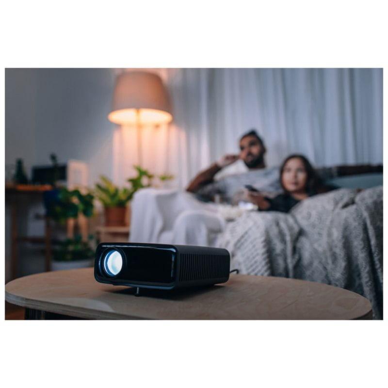 Vue générale d'un couple regardant un film dans le salon avec le Projecteur Philips NeoPix 320 NPX320 Noir en perspective