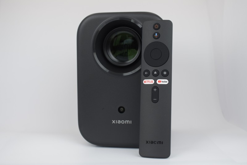 Photo réelle de face avec télécommande du Xiaomi Smart Projector L1 FHD 2GB/16GB Google TV - Projecteur