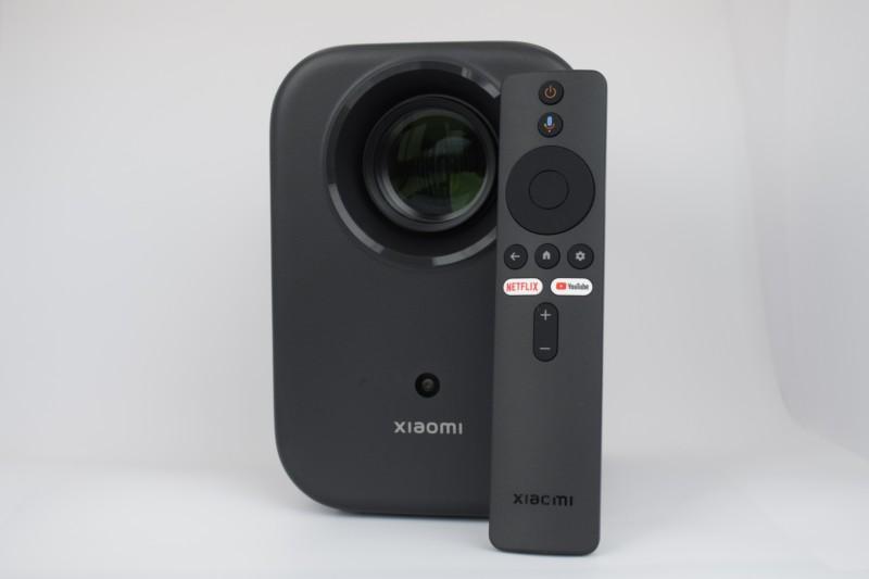 Photo réelle de face avec télécommande du Xiaomi Smart Projector L1 FHD 2GB/16GB Google TV - Projecteur